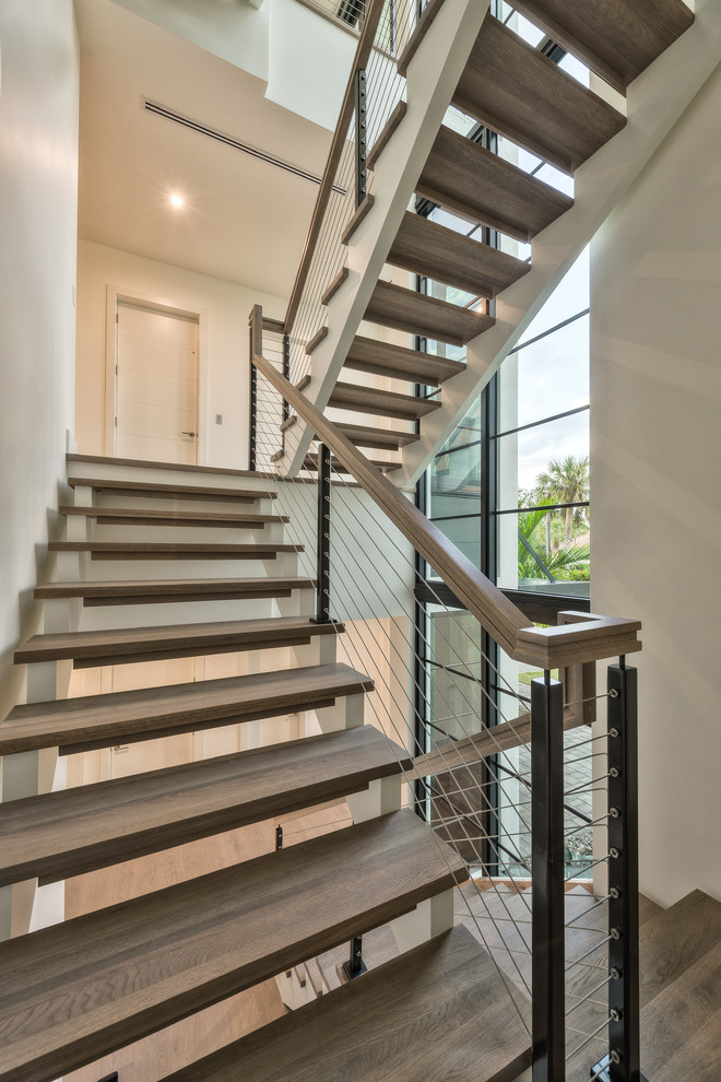 Modelo de escalera minimalista grande con escalones de madera, contrahuellas de madera y barandilla de varios materiales