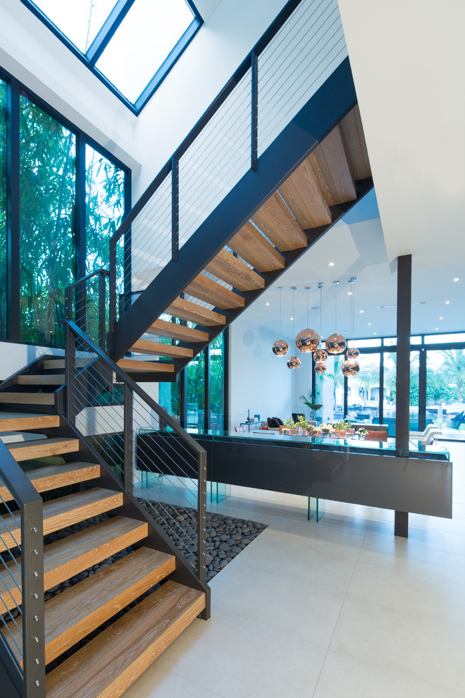 Exempel på en mellanstor modern svängd trappa i trä, med räcke i metall