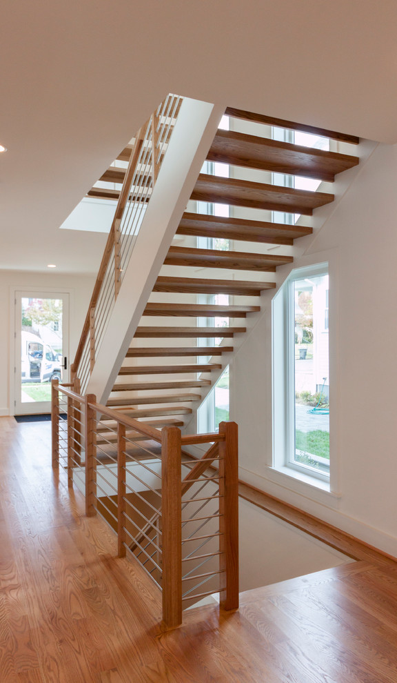 Идея дизайна: большая лестница на больцах в современном стиле с деревянными ступенями и перилами из смешанных материалов