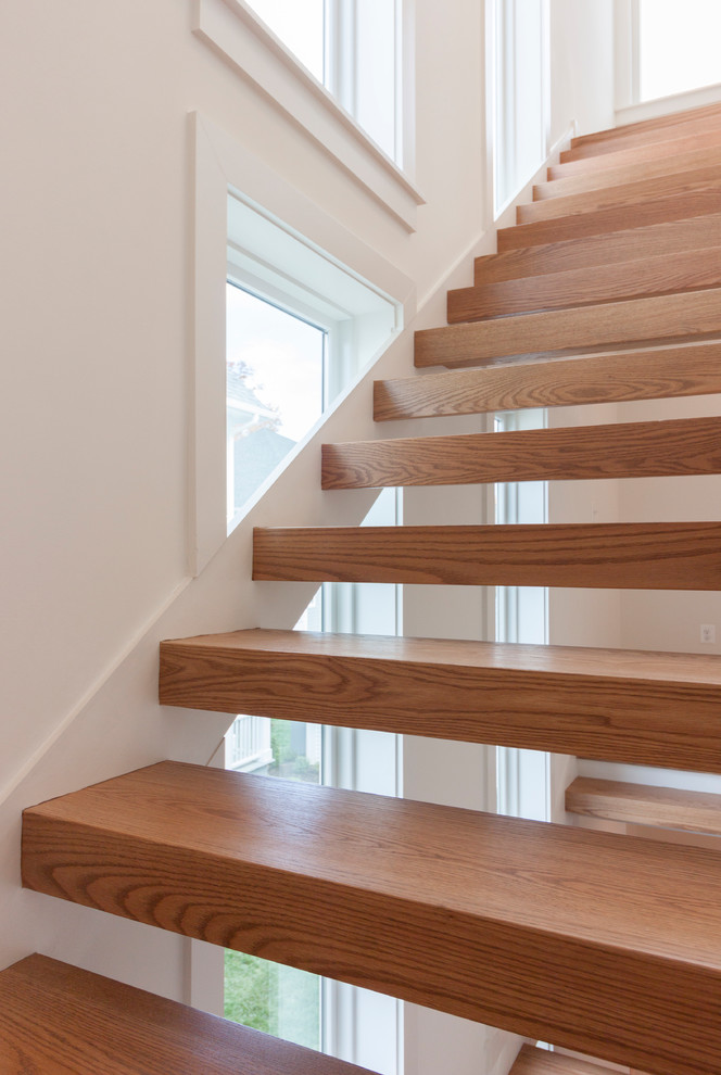 Источник вдохновения для домашнего уюта: большая лестница на больцах в современном стиле с деревянными ступенями и перилами из смешанных материалов