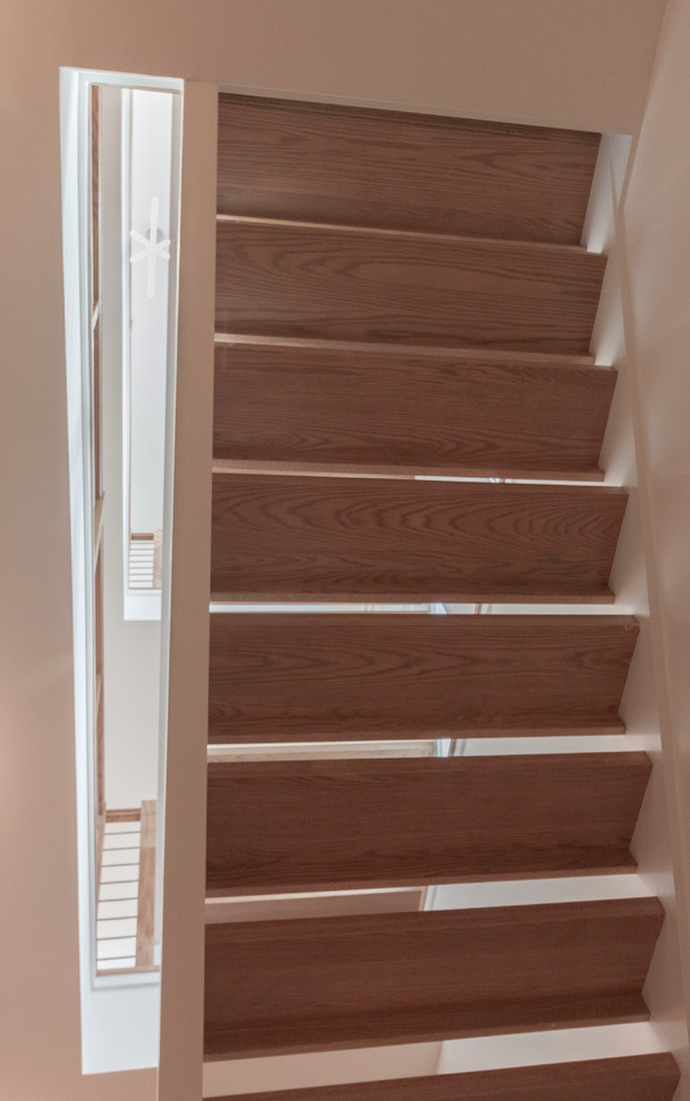 Ejemplo de escalera suspendida actual grande con escalones de madera y barandilla de varios materiales