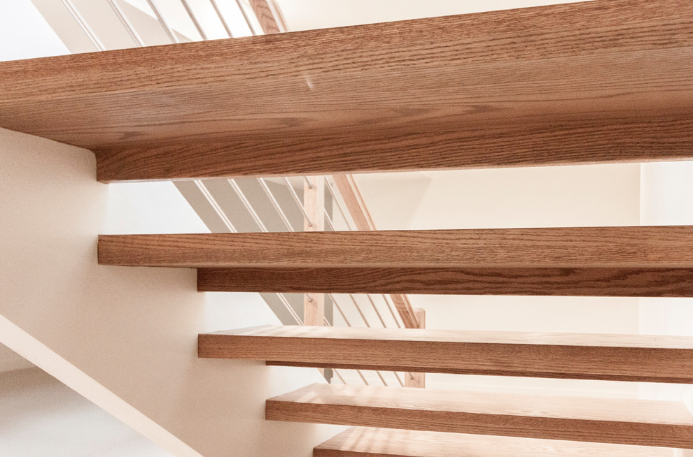 Ejemplo de escalera suspendida contemporánea grande con escalones de madera y barandilla de varios materiales