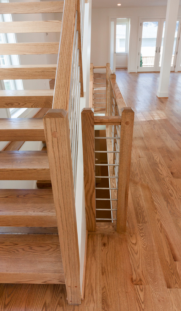 Modern inredning av en stor flytande trappa i trä, med räcke i flera material
