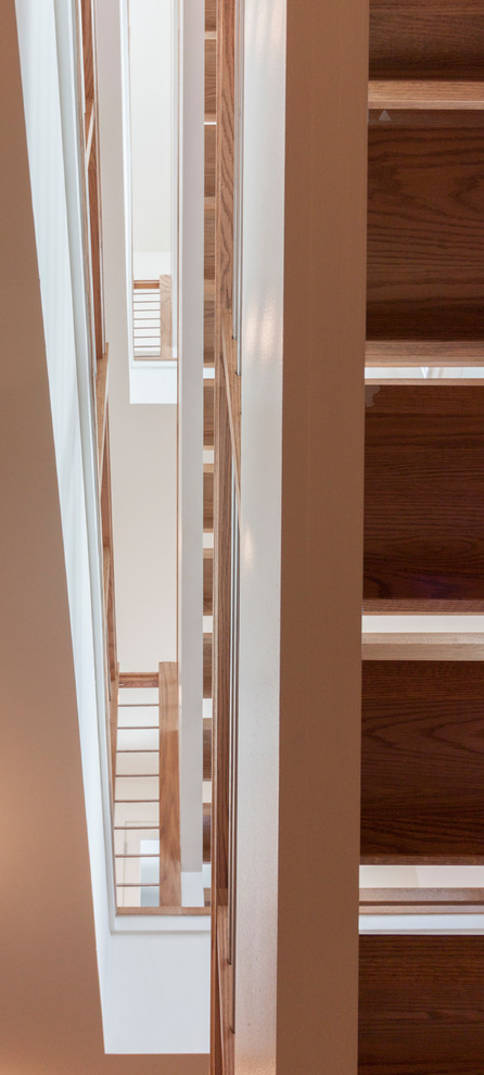 Cette image montre un grand escalier flottant design avec des marches en bois et un garde-corps en matériaux mixtes.