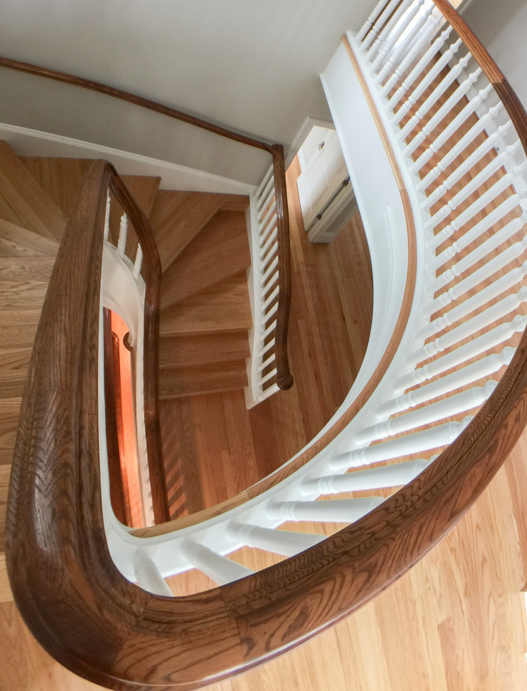 Idées déco pour un très grand escalier classique en U avec des marches en bois, des contremarches en bois et un garde-corps en bois.