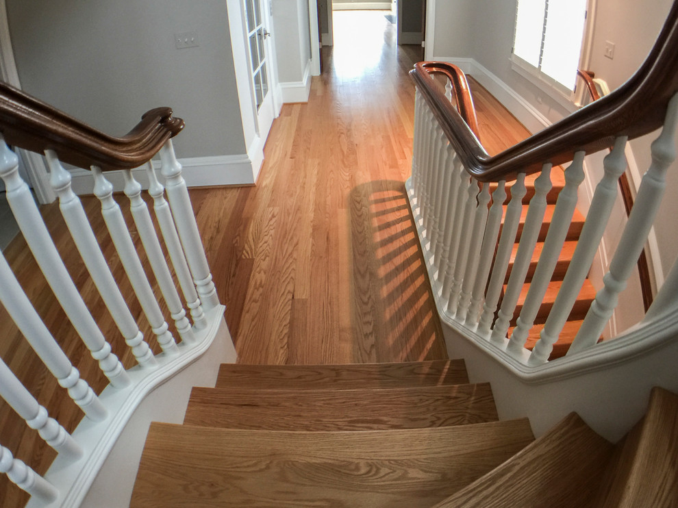 This is an example of an expansive classic wood u-shaped wood railing staircase in DC Metro with wood risers.