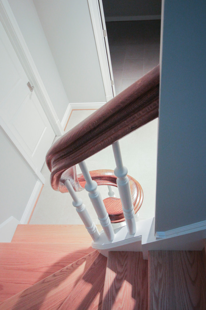 Ejemplo de escalera en U tradicional extra grande con escalones de madera, contrahuellas de madera y barandilla de madera