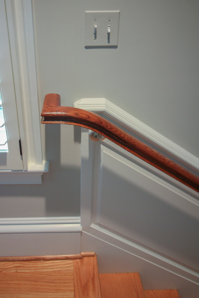Photo of an expansive traditional wood u-shaped wood railing staircase in DC Metro with wood risers.