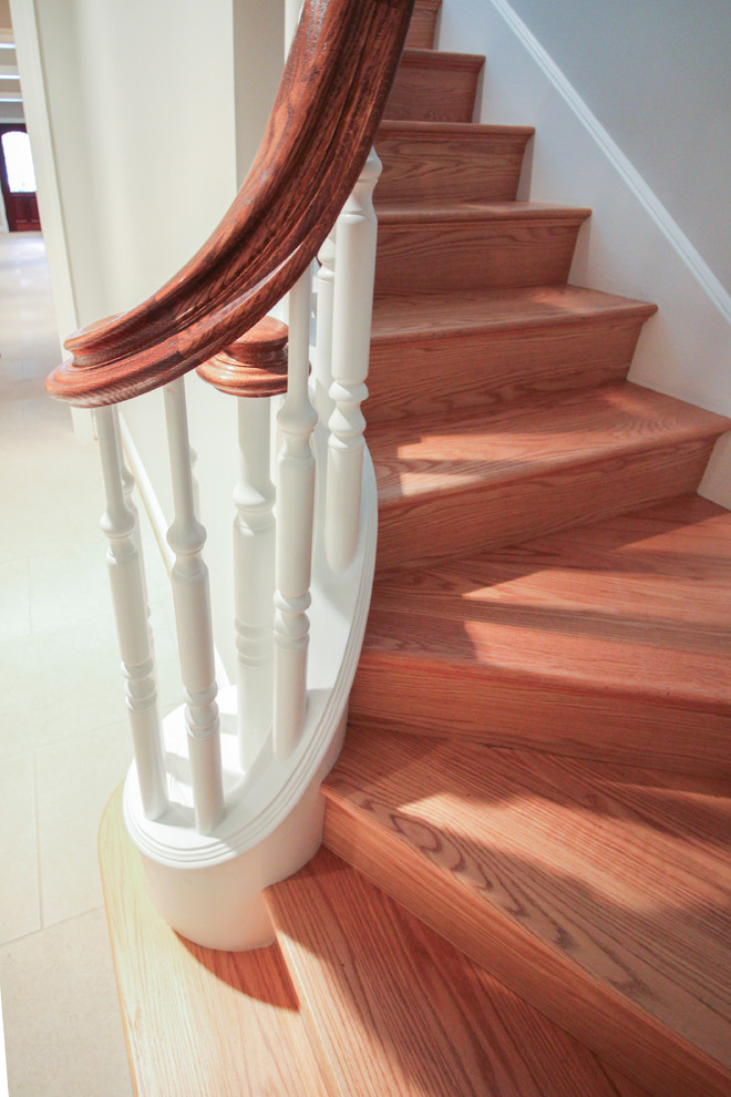This is an example of an expansive classic wood u-shaped wood railing staircase in DC Metro with wood risers.