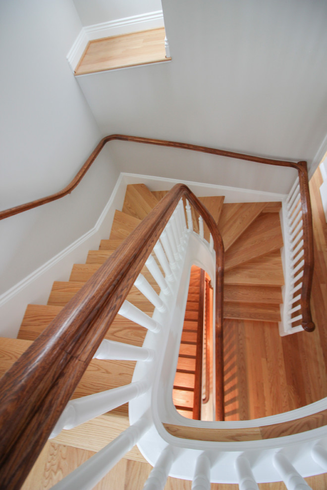 Ejemplo de escalera en U tradicional extra grande con escalones de madera, contrahuellas de madera y barandilla de madera