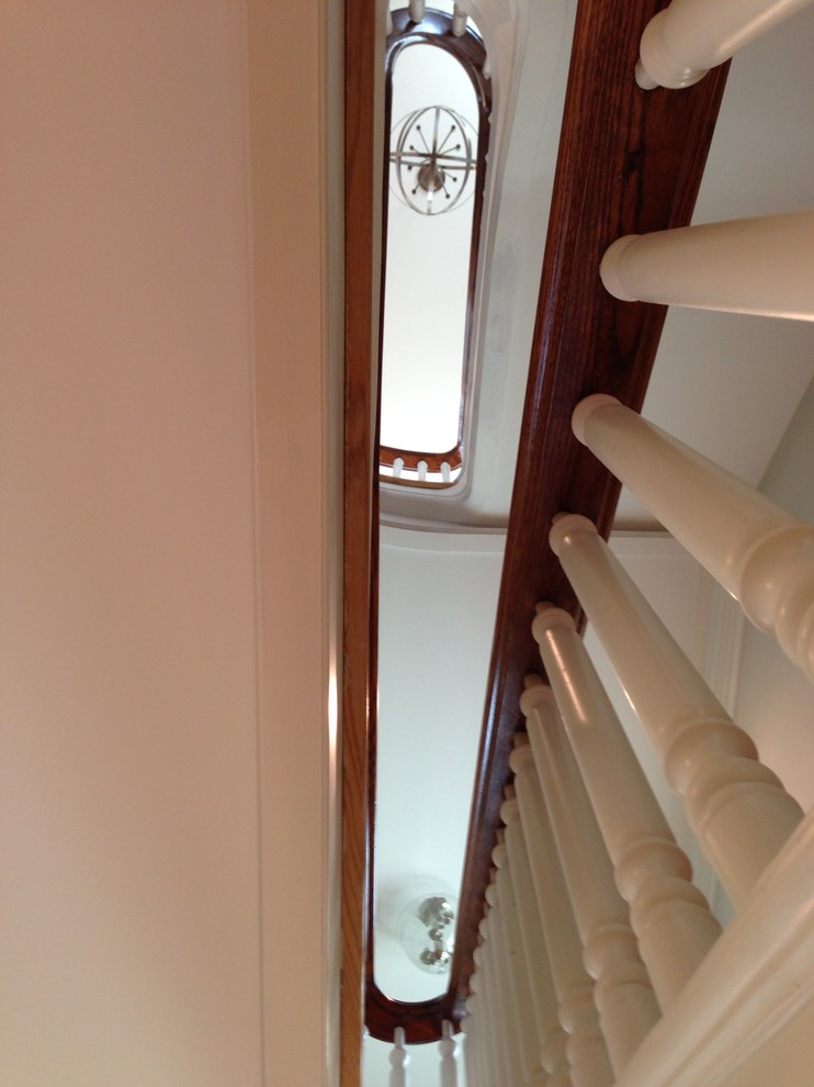 Foto de escalera en U clásica extra grande con escalones de madera, contrahuellas de madera y barandilla de madera