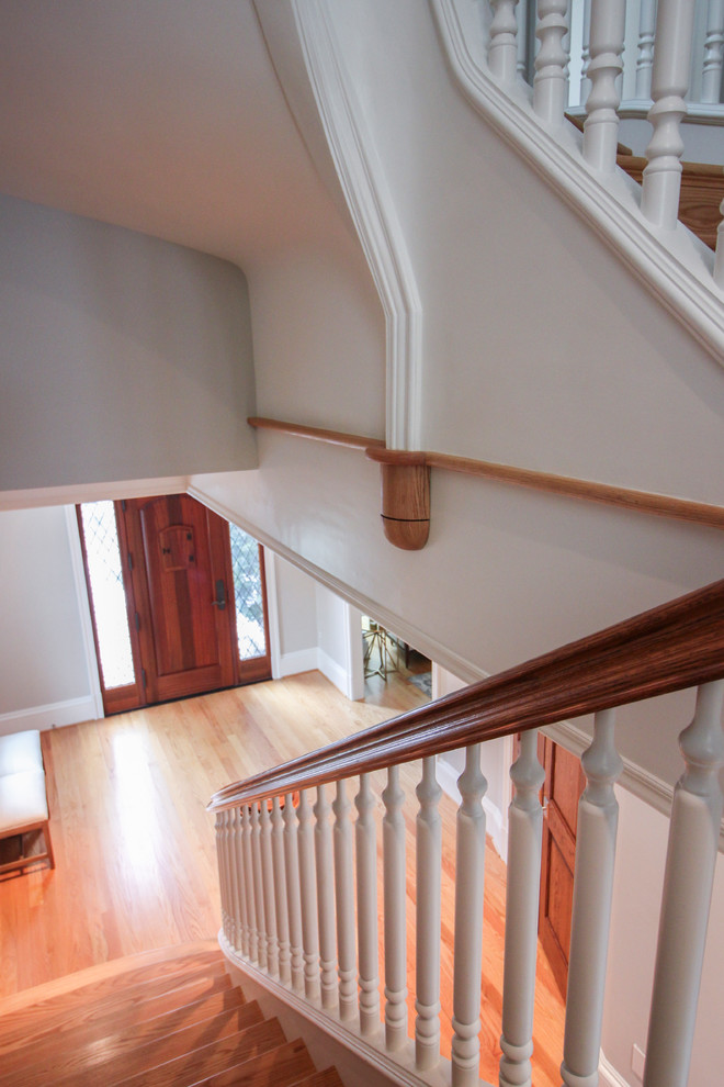 Huge elegant wooden u-shaped wood railing staircase photo in DC Metro with wooden risers