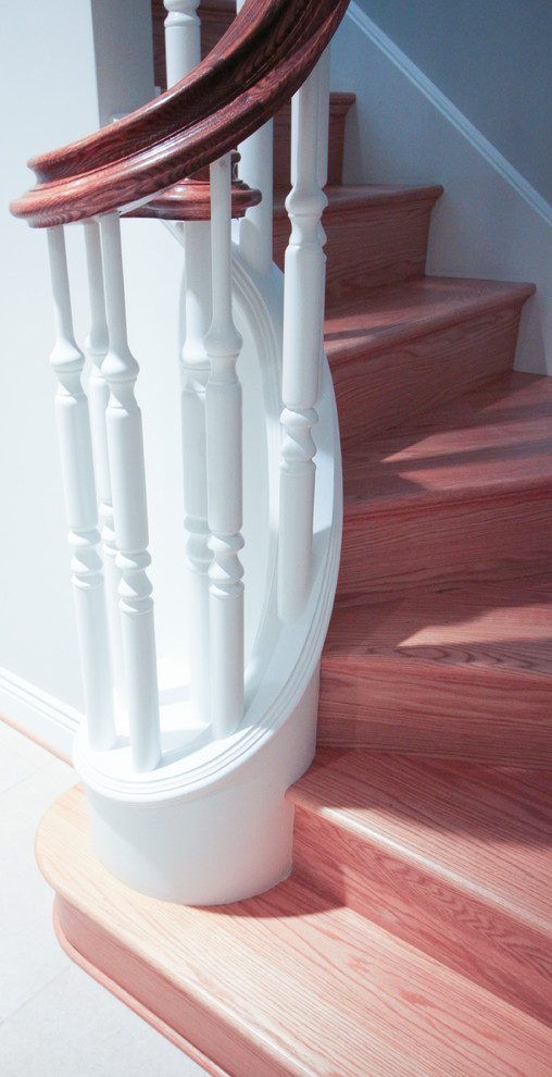 Пример оригинального дизайна: огромная п-образная деревянная лестница в классическом стиле с деревянными ступенями и деревянными перилами