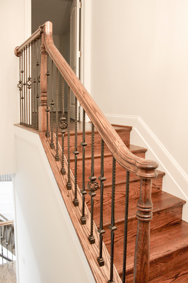 This is an example of a large contemporary wood curved mixed railing staircase in DC Metro with wood risers.