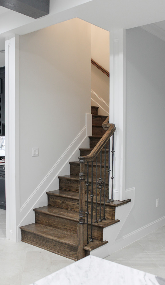 Ejemplo de escalera curva actual grande con escalones de madera, contrahuellas de madera y barandilla de varios materiales