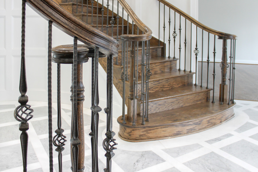 Modelo de escalera curva contemporánea grande con escalones de madera, contrahuellas de madera y barandilla de varios materiales