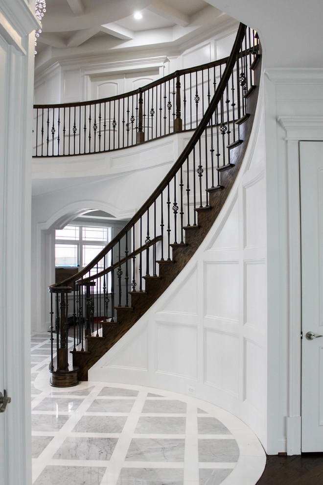 Imagen de escalera curva contemporánea grande con escalones de madera, contrahuellas de madera y barandilla de varios materiales
