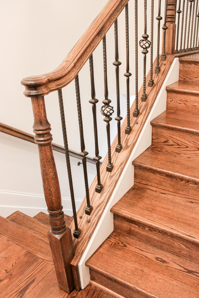 Ejemplo de escalera curva contemporánea grande con escalones de madera, contrahuellas de madera y barandilla de varios materiales