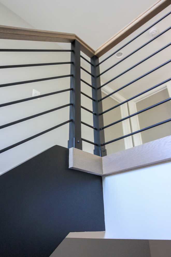 Идея дизайна: большая лестница на больцах в стиле модернизм с деревянными ступенями и перилами из смешанных материалов