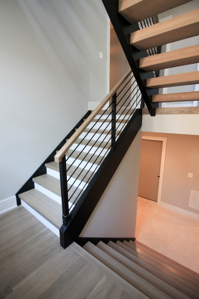 Источник вдохновения для домашнего уюта: большая лестница на больцах в стиле модернизм с деревянными ступенями и перилами из смешанных материалов