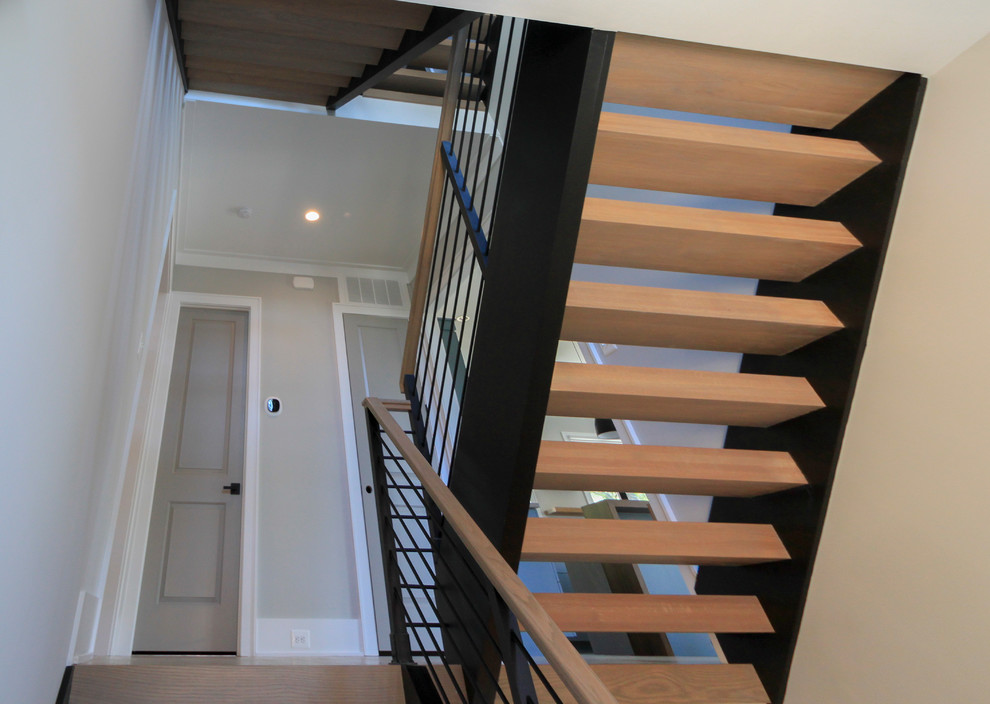 Пример оригинального дизайна: большая лестница на больцах в стиле модернизм с деревянными ступенями и перилами из смешанных материалов