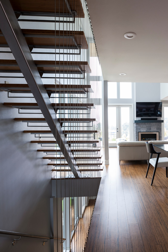 Inspiration for a medium sized contemporary wood straight staircase in Seattle with open risers and feature lighting.
