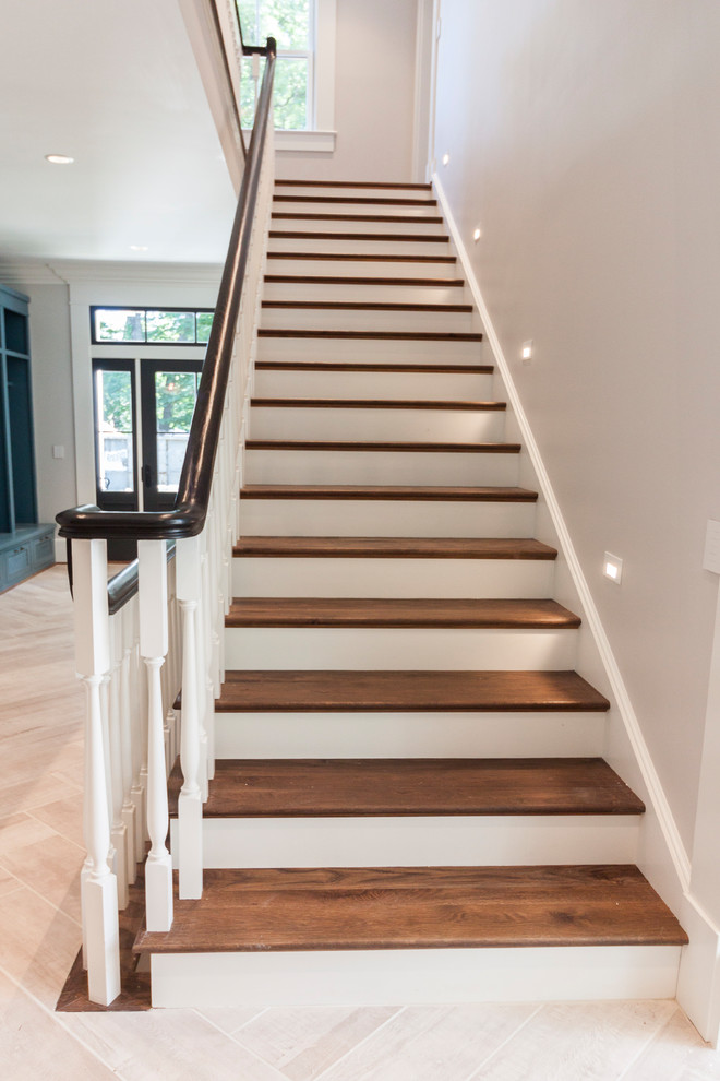 Ejemplo de escalera recta romántica grande con escalones de madera, contrahuellas de madera y barandilla de madera
