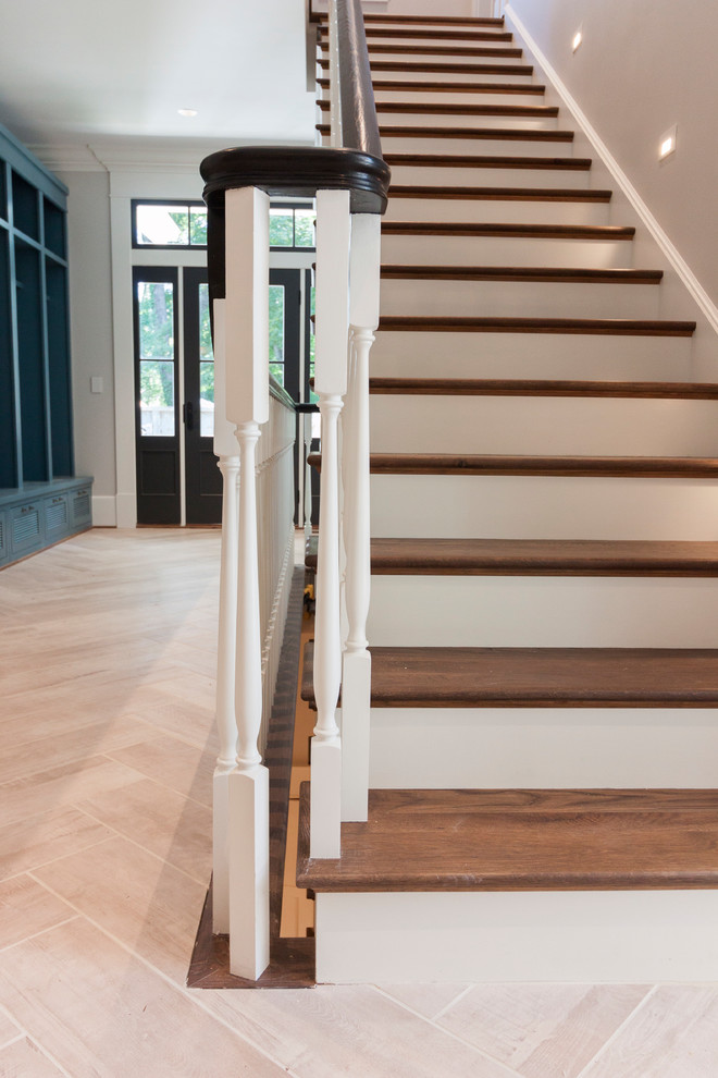 На фото: большая прямая деревянная лестница в стиле шебби-шик с деревянными ступенями и деревянными перилами с