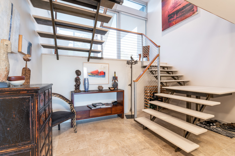 Cette photo montre un escalier sans contremarche tendance en U de taille moyenne avec des marches en pierre calcaire et un garde-corps en câble.