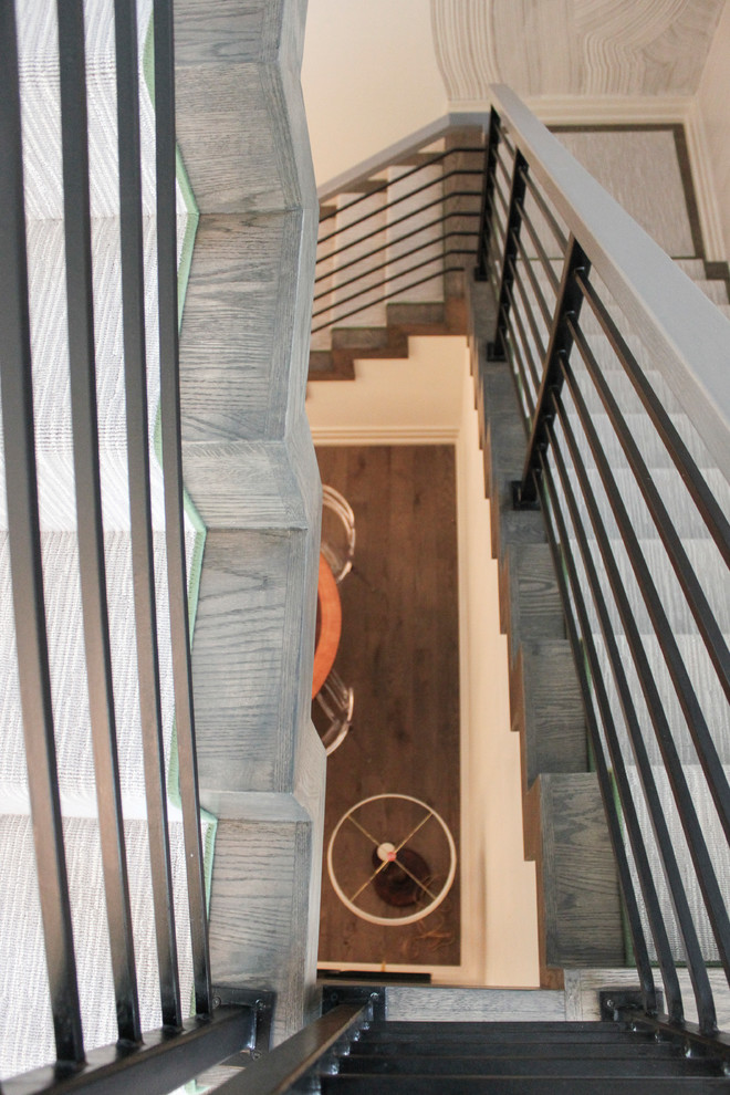 Foto di una grande scala sospesa eclettica con pedata in legno, alzata in legno e parapetto in metallo