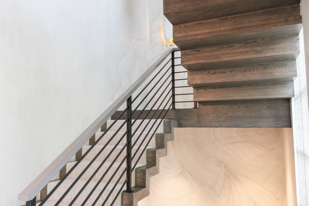 Ejemplo de escalera suspendida bohemia grande con escalones de madera, contrahuellas de madera y barandilla de metal