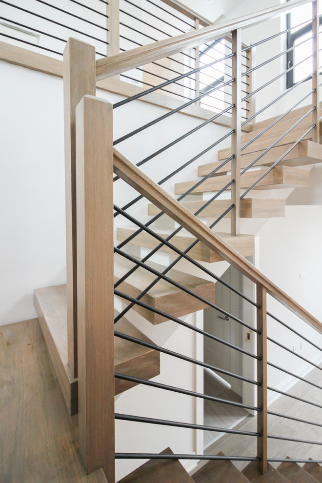 На фото: большая п-образная лестница в современном стиле с деревянными ступенями и перилами из тросов