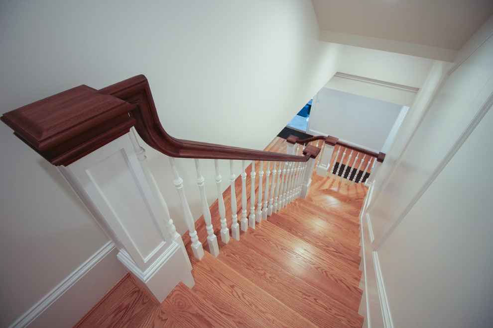 Imagen de escalera en U de estilo americano de tamaño medio con escalones de madera, contrahuellas de madera y barandilla de madera