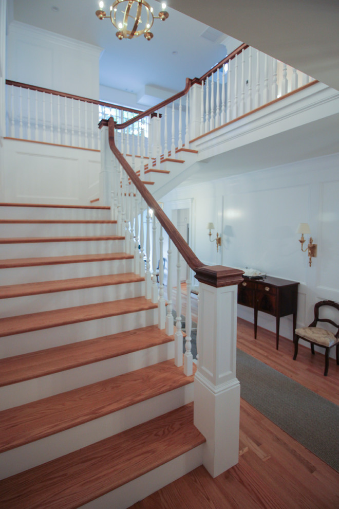 Inspiration for a medium sized classic wood u-shaped wood railing staircase in DC Metro with wood risers.