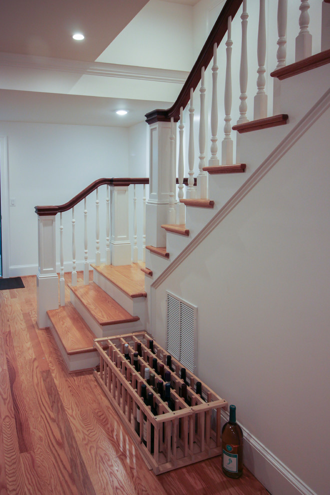 Imagen de escalera en U de estilo americano de tamaño medio con escalones de madera, contrahuellas de madera y barandilla de madera