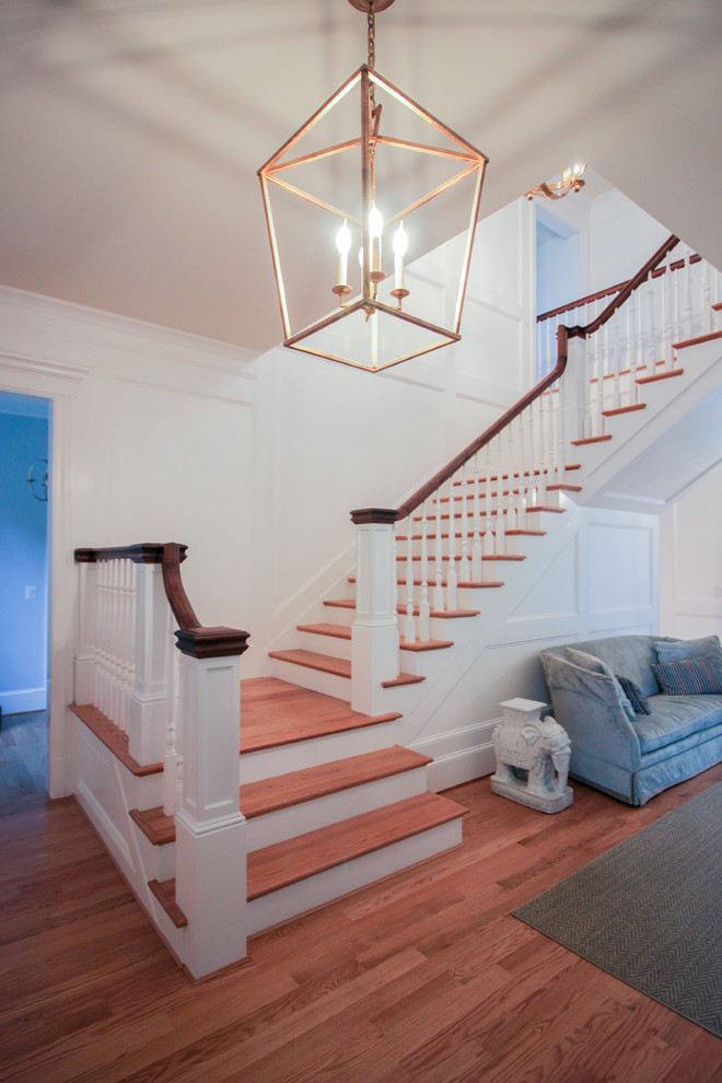 Imagen de escalera en U de estilo americano de tamaño medio con escalones de madera, contrahuellas de madera y barandilla de madera
