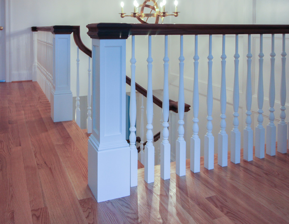 Diseño de escalera en U de estilo americano de tamaño medio con escalones de madera, contrahuellas de madera y barandilla de madera
