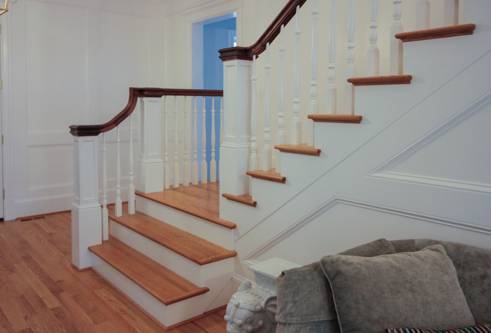Foto de escalera en U de estilo americano de tamaño medio con escalones de madera, contrahuellas de madera y barandilla de madera