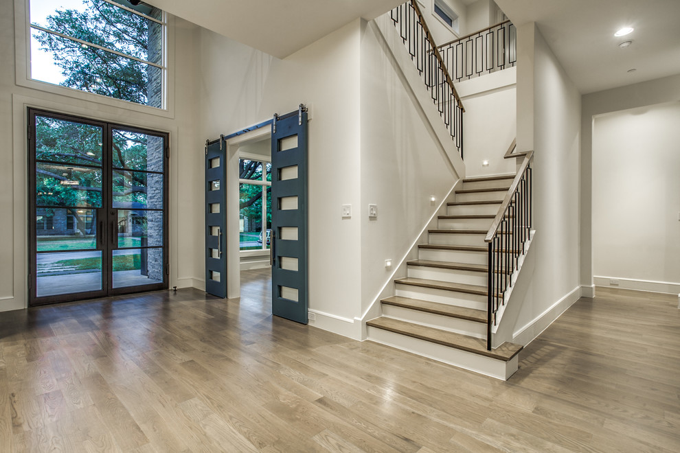 This is an example of a modern wood u-shaped metal railing staircase in Dallas with painted wood risers.
