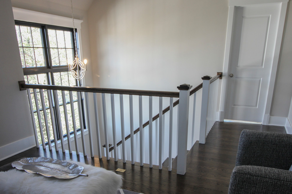 Imagen de escalera en U minimalista de tamaño medio con escalones de travertino, contrahuellas de madera y barandilla de madera