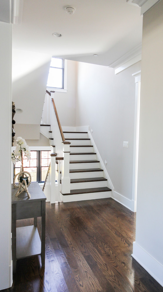 Foto de escalera en U moderna de tamaño medio con escalones de travertino, contrahuellas de madera y barandilla de madera