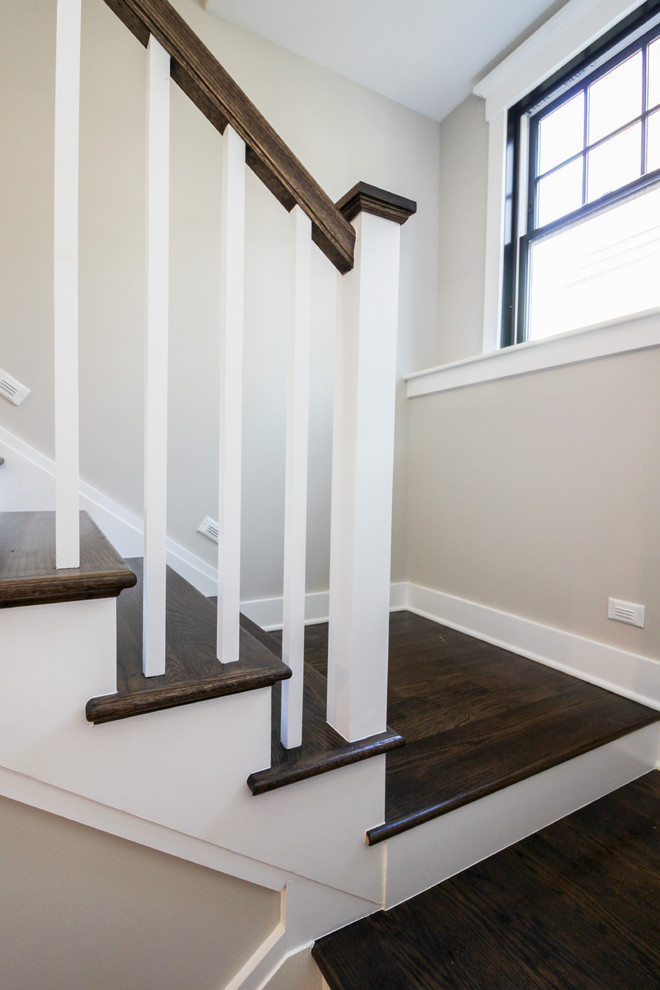 Foto de escalera en U minimalista de tamaño medio con escalones de travertino, contrahuellas de madera y barandilla de madera