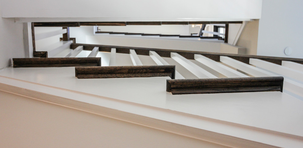 Ejemplo de escalera en U moderna de tamaño medio con escalones de travertino, contrahuellas de madera y barandilla de madera