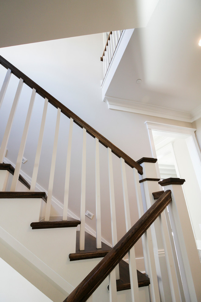 На фото: п-образная деревянная лестница среднего размера в стиле модернизм с ступенями из травертина и деревянными перилами с