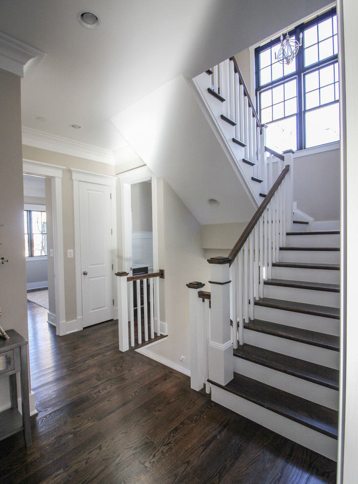Ejemplo de escalera en U minimalista de tamaño medio con escalones de travertino, contrahuellas de madera y barandilla de madera