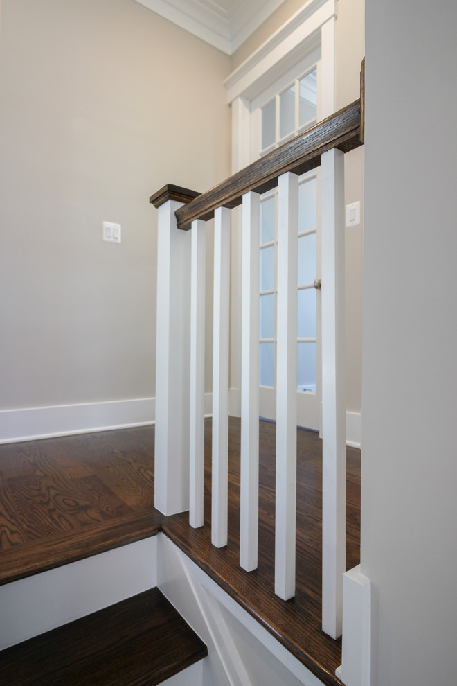 Diseño de escalera en U minimalista de tamaño medio con escalones de travertino, contrahuellas de madera y barandilla de madera