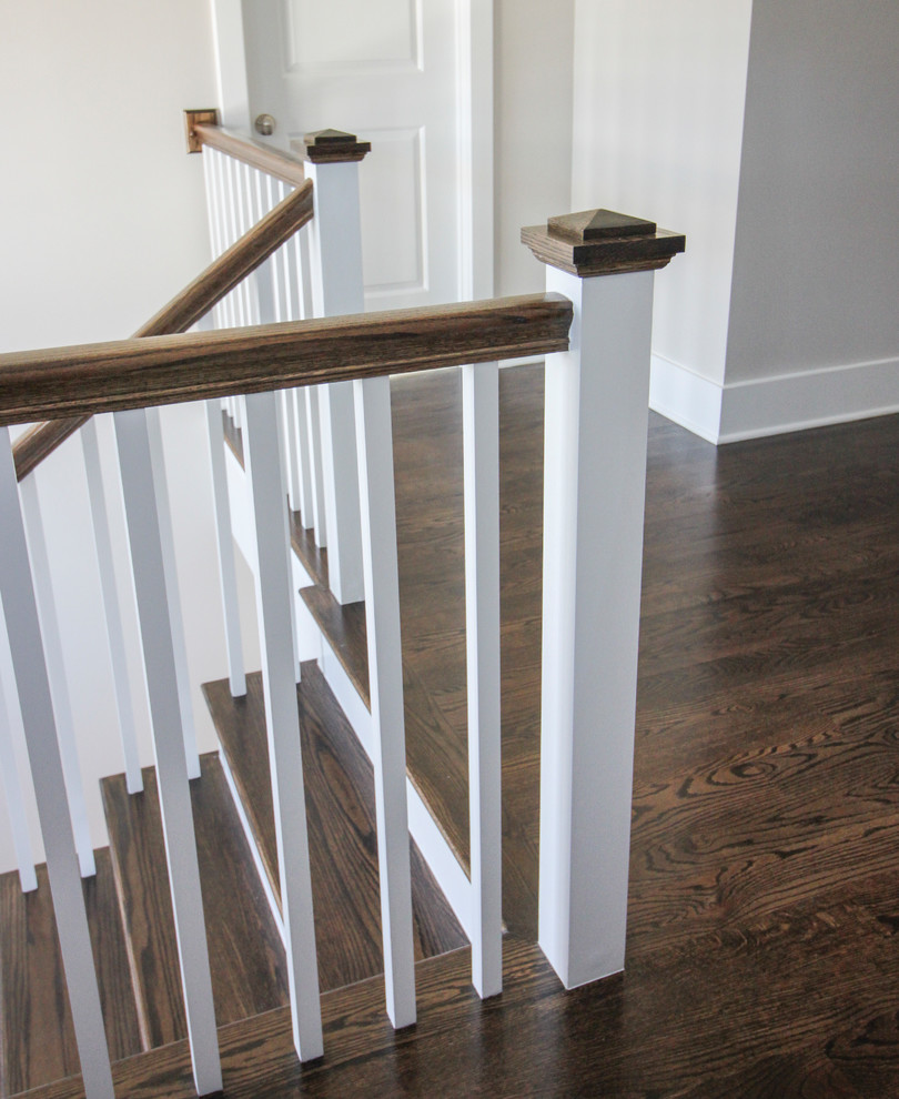 Modelo de escalera en U moderna de tamaño medio con escalones de travertino, contrahuellas de madera y barandilla de madera