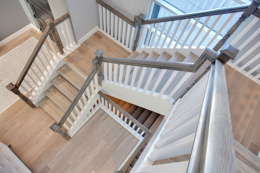 На фото: лестница на больцах в стиле неоклассика (современная классика) с деревянными ступенями и крашенными деревянными подступенками