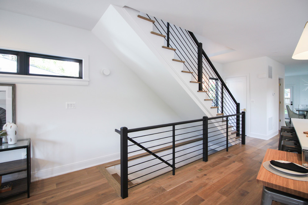 Diseño de escalera recta moderna grande con escalones de madera, contrahuellas de madera y barandilla de varios materiales