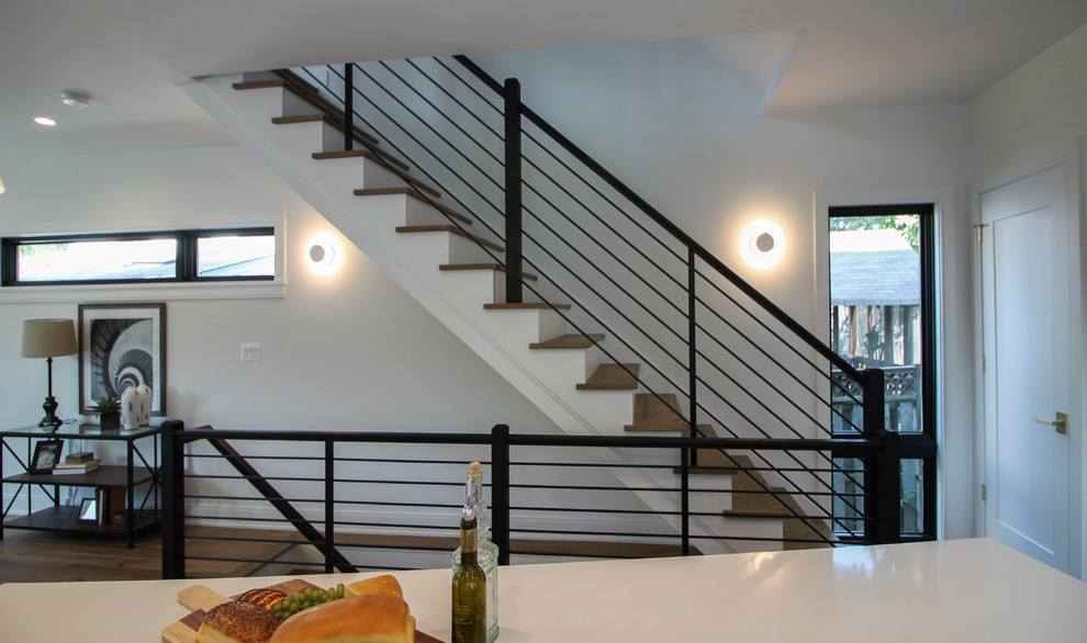 Ejemplo de escalera recta minimalista grande con escalones de madera, contrahuellas de madera y barandilla de varios materiales